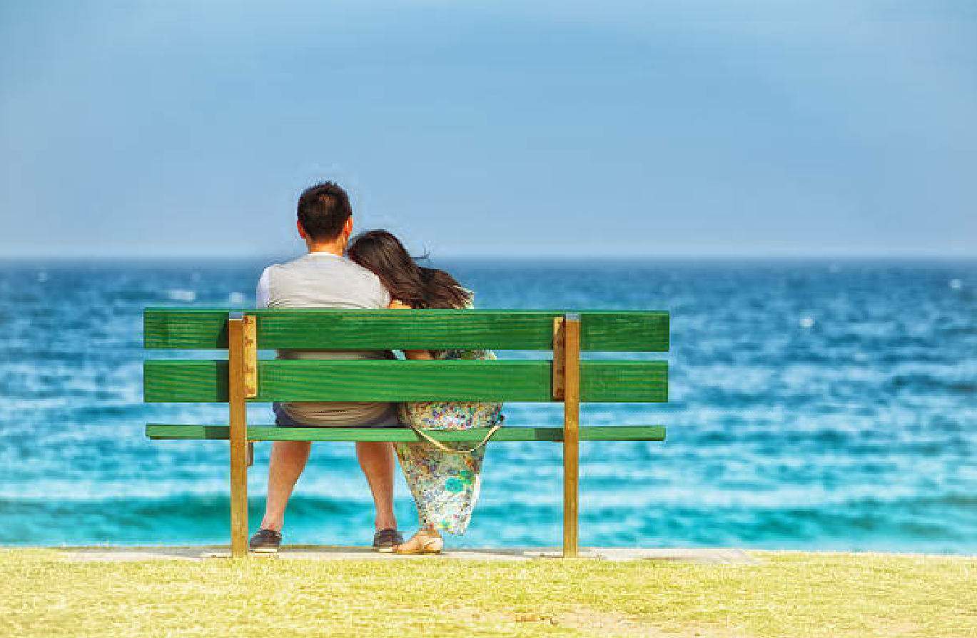 couple_sitting_on_a_bench_looking_out_to_sea couple_sitting_on_a_bench_looking_out_to_sea